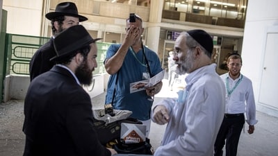 A doctor wearing a tefillin, a small black leather box with leather straps containing scrolls with Torah verses, preforms a prayer at the Soroka Hospital after the facility was struck by an Iranian missile. (AFP) A doctor wearing a tefillin, a small black leather box with leather straps containing scrolls with Torah verses, preforms a prayer at the Soroka Hospital after the facility was struck by an Iranian missile. (AFP)