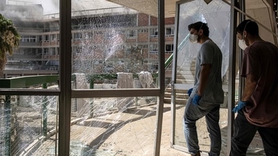 Emergency workers walk through a destroyed door at a building at Soroka Hospital after the facility was struck by an Iranian missile. (AFP) Emergency workers walk through a destroyed door at a building at Soroka Hospital after the facility was struck by an Iranian missile. (AFP)