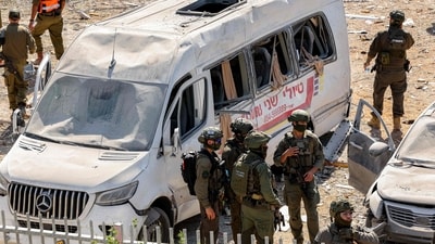Israeli security forces gather by a damaged minibus at the scene of a building that was hit by an Iranian missile near the hospital. (AFP) Israeli security forces gather by a damaged minibus at the scene of a building that was hit by an Iranian missile near the hospital. (AFP)