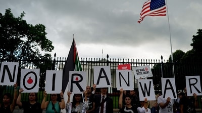 Demonstrators hold signs during a protest against war with Iran outside the White House in Washington, DC, US, on Wednesday, June 18, 2025 (Bloomberg)