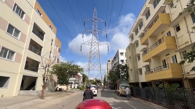 the rider can be seen navigating a stretch of road where an imposing high-tension (HT) transmission tower obstructs the path. (X/@punitpalial) the rider can be seen navigating a stretch of road where an imposing high-tension (HT) transmission tower obstructs the path. (X/@punitpalial)
