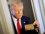 President Donald Trump holds up the $5 million gold card President Donald Trump holds up the $5 million gold card