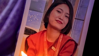 A woman holds a portrait of Lamnunthem Singson, an air hostess who died in the Air India place crash in Ahmedabad, during a candlelight prayer service. (PTI) A woman holds a portrait of Lamnunthem Singson, an air hostess who died in the Air India place crash in Ahmedabad, during a candlelight prayer service. (PTI)