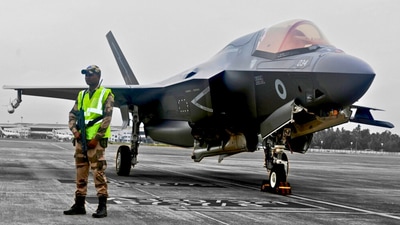 A CISF personnel stand guard near the British F-35 fighter jet that made an emergency landing after running low on fuel at the Thiruvananthapuram International Airport on Saturday night. (X/CISFHQrs) A CISF personnel stand guard near the British F-35 fighter jet that made an emergency landing after running low on fuel at the Thiruvananthapuram International Airport on Saturday night. (X/CISFHQrs)