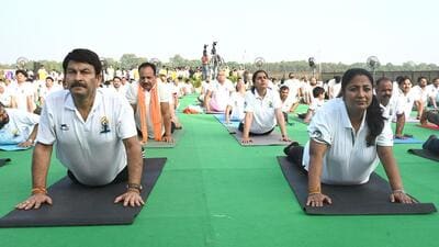 Delhi chief minister Rekha Gupta and MP Manoj Tiwari perform yoga along with hundreds of participants at the Yamuna Vihar Water Sports Club on Saturday. (Sonu Mehta/HT Photo)