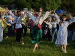 People wearing traditional Ukrainian clothing dance in circle during a traditional midsummer celebration in Pyrohiv, Ukraine, outside of Kyiv, Saturday, June 21, 2025. (AP Photo/Efrem Lukatsky)