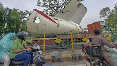A truck carrying wreckage of the Air India plane that crashed into a medical hostel and its canteen complex passes by, in Ahmedabad, Gujarat, on Sunday. (PTI) A truck carrying wreckage of the Air India plane that crashed into a medical hostel and its canteen complex passes by, in Ahmedabad, Gujarat, on Sunday. (PTI)