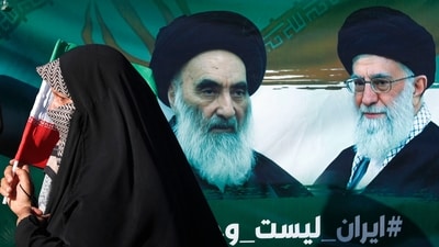An Iraqi woman walks past a portrait of Iraq's top Shiite cleric Ayatollah Ali al-Sistani and Iran's supreme leader Ayatollah Ali Khamenei during march in the Kadhimiya district of Baghdad to protest against Israel's strikes on Iran. (AFP) An Iraqi woman walks past a portrait of Iraq's top Shiite cleric Ayatollah Ali al-Sistani and Iran's supreme leader Ayatollah Ali Khamenei during march in the Kadhimiya district of Baghdad to protest against Israel's strikes on Iran. (AFP)