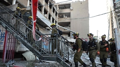 Israeli first responders enter a building that was hit by an Iranian strike in Haifa, amid the ongoing fire exchange between Israel and Iran. (Fadel Senna/AFP) Israeli first responders enter a building that was hit by an Iranian strike in Haifa, amid the ongoing fire exchange between Israel and Iran. (Fadel Senna/AFP)