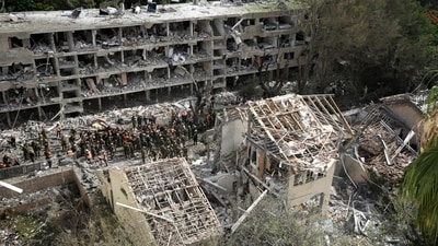 Rescue workers and firefighters survey the site of a direct missile strike launched from Iran in Tel Aviv, Israel, on Sunday. (AP) Rescue workers and firefighters survey the site of a direct missile strike launched from Iran in Tel Aviv, Israel, on Sunday. (AP)