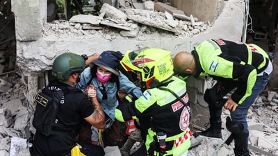 Rescue personnel evacuate a resident from under a building at an impacted site after a missile attack from Iran, amid the Iran-Israel conflict in Tel Aviv, Israel June 22, 2025. (Reuters)