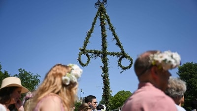 People walk at the mid pole during Midsummer celebrations on the island of Gotland, Sweden, on June 20, 2025. The traditional festivities mark the summer solstice with flower crowns, dancing, and maypole raising across the country. (Photo by Jonathan NACKSTRAND / AFP) (AFP) People walk at the mid pole during Midsummer celebrations on the island of Gotland, Sweden, on June 20, 2025. The traditional festivities mark the summer solstice with flower crowns, dancing, and maypole raising across the country. (Photo by Jonathan NACKSTRAND / AFP) (AFP)
