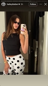 Hailey wore a black top and polka-dotted pants as she posed in front of a mirror with her phone. Hailey wore a black top and polka-dotted pants as she posed in front of a mirror with her phone.