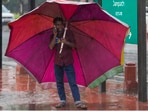 A man takes shelter under a large umbrella amid rain, in New Delhi, Tuesday, June 17, 2025. A man takes shelter under a large umbrella amid rain, in New Delhi, Tuesday, June 17, 2025.