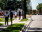 Residents and other people look on as police and emergency response vehicles line the street near the scene of a shooting at CrossPointe Community Church on June 22, 2025, in Wayne, Michigan. Residents and other people look on as police and emergency response vehicles line the street near the scene of a shooting at CrossPointe Community Church on June 22, 2025, in Wayne, Michigan.