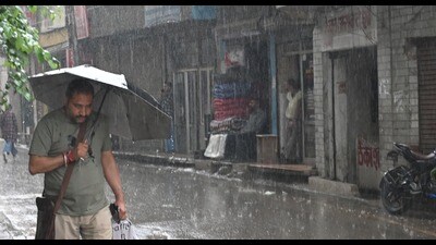 A man walks with umbrella amid rain in Mandi on Monday. (Birbal Sharma/HT)