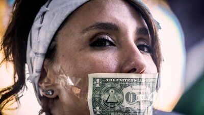 A protester with a US dollar note taped over her mouth participates in a demonstration in support of Iran and Palestinians in Gaza, and against the actions of Israel and the United States in Sydney on June 22, 2025. (AFP)