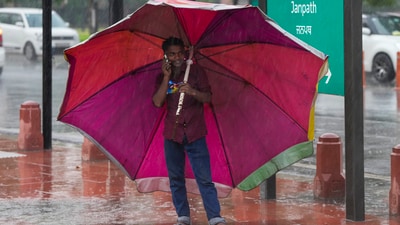 A man takes shelter under a large umbrella amid rain, in New Delhi, Tuesday, June 17, 2025. (PTI) A man takes shelter under a large umbrella amid rain, in New Delhi, Tuesday, June 17, 2025. (PTI)