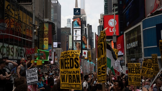 Protesters hold signs during a protest against U.S. strikes on Iran, Sunday, June 22, 2025, in New York. AP/PTI(AP06_23_2025_000007B) (AP)
