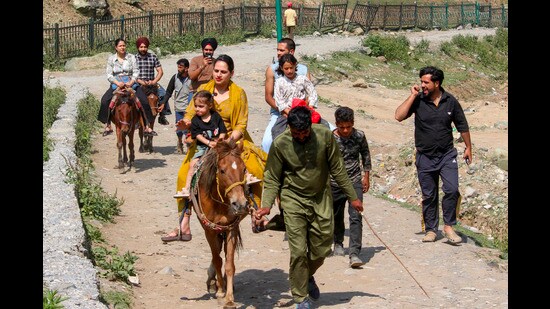 Tourists take a horse ride at Sonamarg in Ganderbal district in Jammu & Kashmir on Sunday. (PTI)