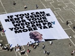 A large banner against Amazon founder Jeff Bezos lies on the ground, placed by Greenpeace Italy activists and UK activist group Everyone Hates Elon, in St. Mark's Square, ahead of the expected wedding of Bezos and Lauren Sanchez, in Venice, Italy, June 23, 2025. REUTERS/Yara Nardi
