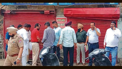 Civic body officials outside a meat shop on Tajpur road in Ludhiana on Tuesday. (HT Photo)