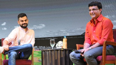 Virat Kohli, left, and Sourav Ganguly share a laugh during an event in 2018 (AFP)