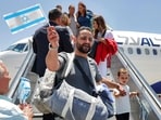 Jewish migrants making Aliyah (immigration to Israel) are handed miniature Israeli flags upon disembarking from an Israeli El Al airlines aircraft after their arrival at Ben Gurion Airport in Lod on June 25, 2025. Jewish migrants making Aliyah (immigration to Israel) are handed miniature Israeli flags upon disembarking from an Israeli El Al airlines aircraft after their arrival at Ben Gurion Airport in Lod on June 25, 2025.