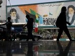 People walk next to a mural with a picture of Iran's Supreme Leader, Ayatollah Ali Khamenei, on a street, early hours of ceasefire, in Tehran, Iran, on June 24. People walk next to a mural with a picture of Iran's Supreme Leader, Ayatollah Ali Khamenei, on a street, early hours of ceasefire, in Tehran, Iran, on June 24.