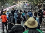 Protesters gather in front of a police cordon backed by a water cannon truck during clashes in downtown Nairobi on June 25, 2025.