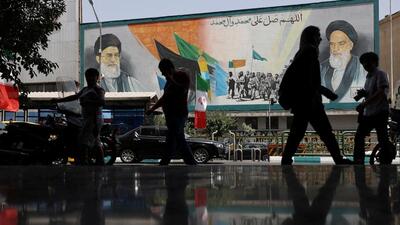 People walk next to a mural with a picture of Iran's Supreme Leader, Ayatollah Ali Khamenei, on a street, early hours of ceasefire, in Tehran, Iran, on June 24. (via REUTERS) People walk next to a mural with a picture of Iran's Supreme Leader, Ayatollah Ali Khamenei, on a street, early hours of ceasefire, in Tehran, Iran, on June 24. (via REUTERS)