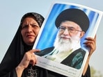 An Iranian woman holds a portrait of supreme leader Ayatollah Ali Khamenei as people celebrate a ceasefire between Iran and Israel at Enghlab Square in the capital Tehran on June 24, 2025.
