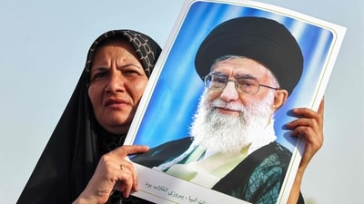 An Iranian woman holds a portrait of supreme leader Ayatollah Ali Khamenei as people celebrate a ceasefire between Iran and Israel at Enghlab Square in the capital Tehran on June 24, 2025. (AFP)