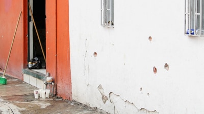 Votive candles are placed near the bullet-riddled house where gunmen opened fire on Tuesday during a party celebrating the Nativity of John the Baptist. (Source: Reuters) (REUTERS)