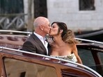 Jeff Bezos, center left, and Lauren Sanchez, center right, kiss as they leave a hotel for their pre wedding reception, in Venice, Italy, Thursday, June 26, 2025.