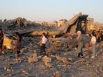 Palestinians walk past the rubble and destroyed vehicles in the Al-Bureij camp in the central Gaza Strip after a house was targeted by an Israeli strike, on June 27, 2025. Palestinians walk past the rubble and destroyed vehicles in the Al-Bureij camp in the central Gaza Strip after a house was targeted by an Israeli strike, on June 27, 2025.