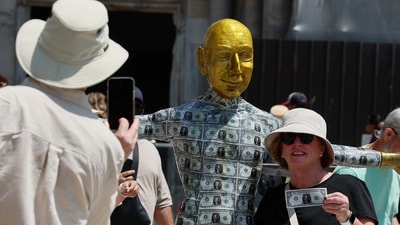 Lifelike statues of Jeff Bezos, especially one covered in fake dollar bills, have become tourist attractions in Venice. Click News/Handout via REUTERS (via REUTERS)