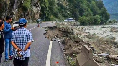 People look at a partially caved in portion of a road, following rainfall at Manali, in Kullu district, Himachal Pradesh. (PTI)