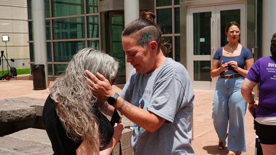 Crystina Page, right, hugs Beth Mosley after a Colorado funeral home owner who stashed nearly 190 decomposing bodies was sentenced to 20 years prison on federal fraud charges. (AP)