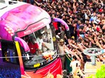 Fans wave as a bus carrying the IPL 2025 winning Royal Challengers Bengaluru team arrives at the Chinnaswamy Stadium, in Bengaluru, Karnataka.