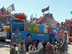 Afghan refugees due for deportation to Afghanistan wait with their belongings outside a holding center near the Pakistan-Afghanistan border.