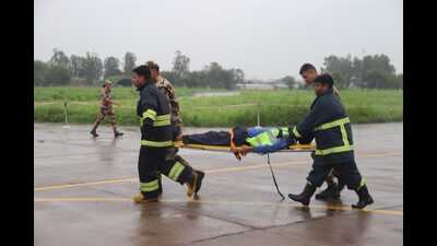 An emergency response team carries an injured passenger on a stretcher during the mock drill at Chandigarh International Airport on Sunday. (HT photo)