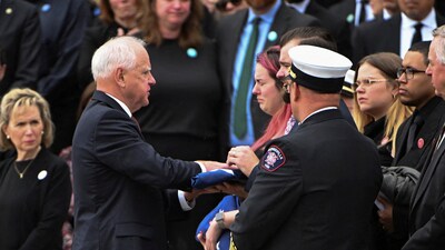 Minnesota Gov. Tim Walz presented Colin Hortman, son of slain Minnesota lawmaker Melissa Hortman and her husband Mark, a flag after the funeral two weeks after they were killed by a man impersonating a police officer, at the Basilica of Saint Mary's in Minneapolis, Minnesota, U.S. June 28, 2025.  REUTERS/Craig Lassig      TPX IMAGES OF THE DAY (REUTERS)
