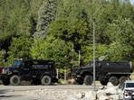 Armored law enforcement vehicles are seen at Cherry Hill Park after multiple firefighters were attacked when responding to a fire in the Canfield Mountain area