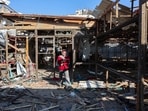 A Palestinian woman walks on debris at Al-Baqa cafeteria which was devastated in an Israeli strike on the Gaza City seafront on June 30, 2025. 