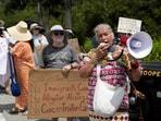 Betty Osceola of the Miccosukee Panther Clan uses a bullhorn as pro-immigrant protesters, environmental groups, Everglades advocates, members of the Miccosukee Native American community and residents gather outside the Dade-Collier Training and Transition Airport as they rally against the state's forthcoming 'Alligator Alcatraz' ICE detention center in Ochopee, Florida