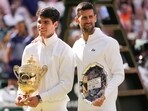 Carlos Alcaraz of Spain holds his trophy as he stands with Novak Djokovic of Serbia after winning the men's singles final at the Wimbledon tennis championships in London, Sunday, July 14, 2024. Carlos Alcaraz of Spain holds his trophy as he stands with Novak Djokovic of Serbia after winning the men's singles final at the Wimbledon tennis championships in London, Sunday, July 14, 2024.