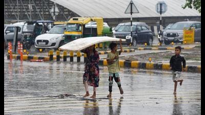 Children try to shield themselves from showers in Gurugram on Monday. (Parveen Kumar/Hindustan Times) Children try to shield themselves from showers in Gurugram on Monday. (Parveen Kumar/Hindustan Times)