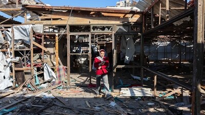 A Palestinian woman walks on debris at Al-Baqa cafeteria which was devastated in an Israeli strike on the Gaza City seafront on June 30, 2025. (AFP)