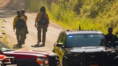 Firefighters pass a law enforcement checkpoint a day after two were fatally shot responding to a fire near Canfield Mountain, Idaho, on June 30, 2025. REUTERS/David Ryder (REUTERS)